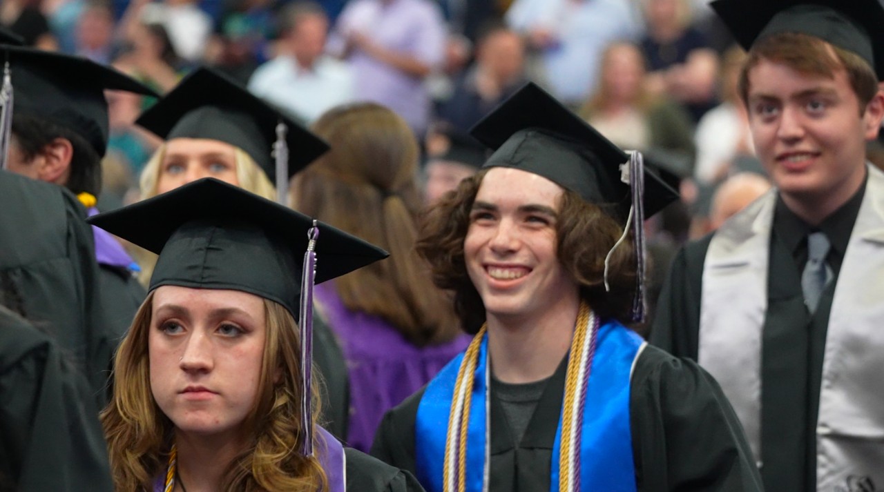 A DCCHS student smiles as he walks into the graduation ceremony.